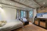 This cozy room features a rustic wooden ceiling and floors, creating a warm and inviting atmosphere.