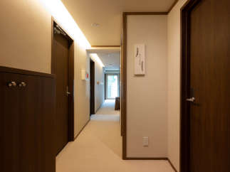 This hallway boasts a sophisticated design with dark wood doors and cabinetry, complemented by soft beige walls and carpeting.