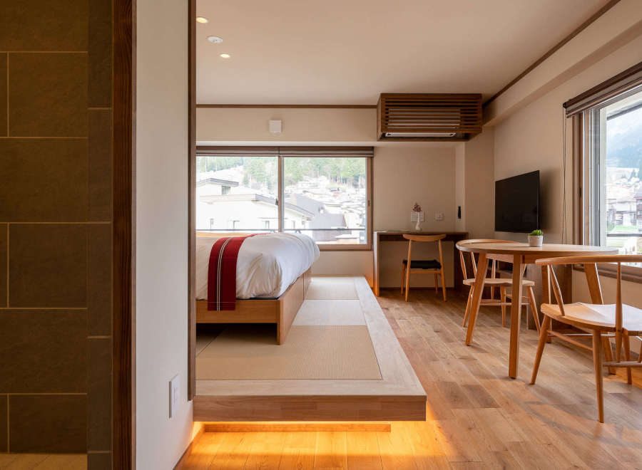 This modern Japanese-style room features a raised platform bed with tatami mats, offering a tranquil and comfortable sleeping space.
