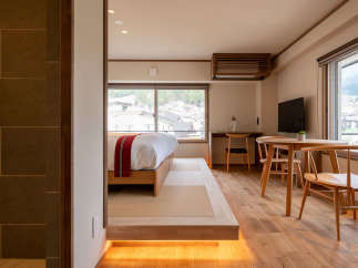 This modern Japanese-style room features a raised platform bed with tatami mats, offering a tranquil and comfortable sleeping space.