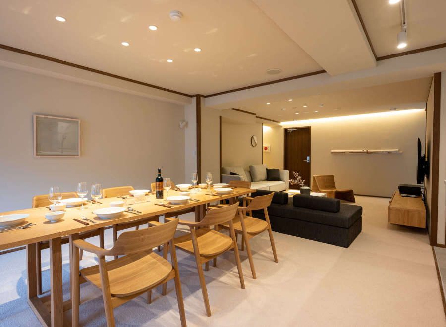This stunning apartment boasts a spacious dining area with a sleek wooden table and comfortable seating for six, perfect for intimate gatherings.