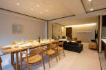 This stunning apartment boasts a spacious dining area with a sleek wooden table and comfortable seating for six, perfect for intimate gatherings.