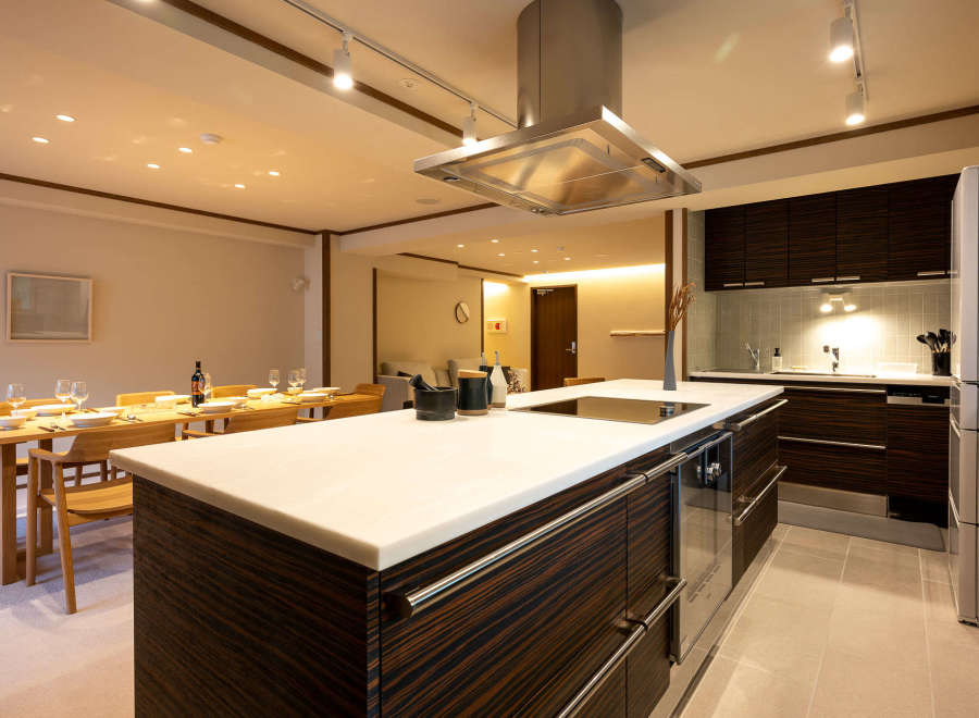 This stunning kitchen boasts a sleek, modern design with dark wood cabinetry and a spacious island featuring a white quartz countertop.