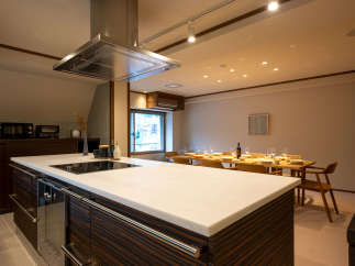 This stunning modern kitchen boasts a sleek island with a white quartz countertop and dark wood cabinetry, perfect for meal preparation and entertaining.