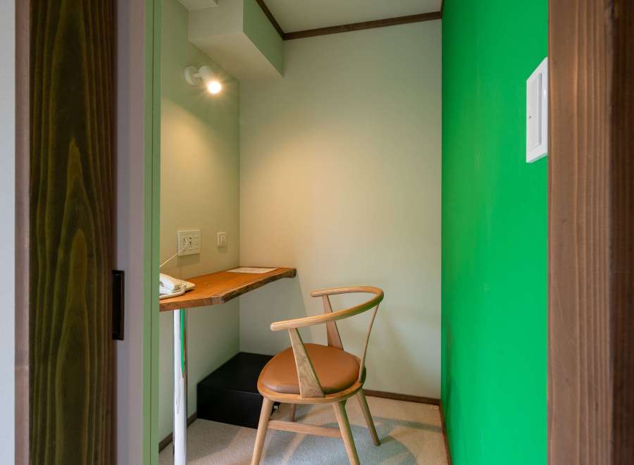 Cozy workspace nook with a wooden desk and chair, perfect for a quiet moment.