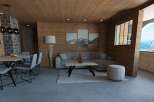 This stunning apartment boasts a spacious open-plan living area with a cozy seating arrangement and a sleek dining set.