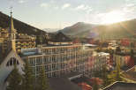 Nestled in a picturesque mountain setting, this stunning hotel boasts a unique architectural design, featuring a modern multi-story building with private balconies and a charming adjacent church.