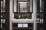 This modern bathroom boasts a sleek, white sink with a dark stone backsplash, complemented by white subway tiles.