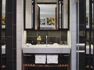 This modern bathroom boasts a sleek, white sink with a dark stone backsplash, complemented by white subway tiles.