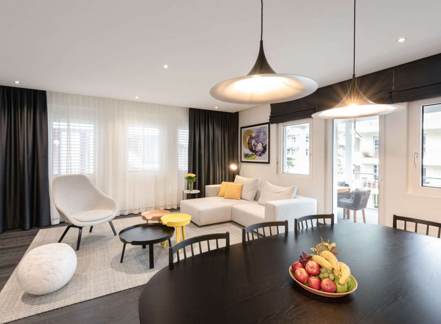 This modern apartment boasts an open-plan living area with floor-to-ceiling windows, offering ample natural light and stunning city views.