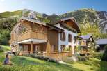 Discover your dream mountain retreat! This stunning property boasts a charming chalet-style design with wooden balconies and stone accents.