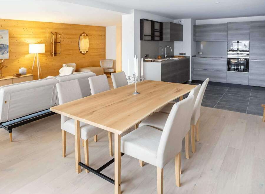 This stunning apartment boasts a spacious open-plan living area with a sleek modern kitchen and a large dining table perfect for entertaining.