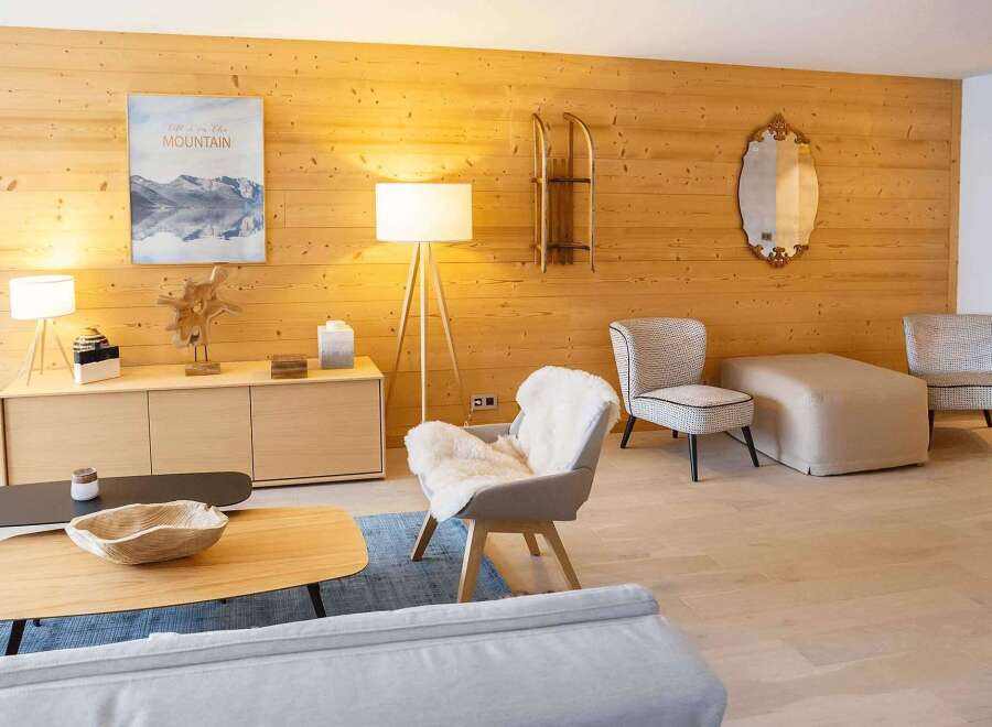 This stunning property boasts a cozy living room with a wood-paneled wall, creating a warm and inviting atmosphere.