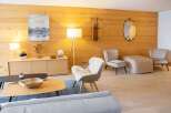 This stunning property boasts a cozy living room with a wood-paneled wall, creating a warm and inviting atmosphere.