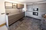 Modern kitchen with sleek gray cabinets and countertops.