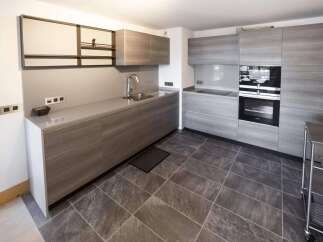 Modern kitchen with sleek gray cabinets and countertops.