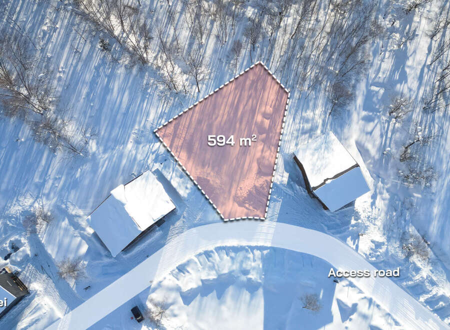 Discover this exceptional 594m² lot nestled in a serene snowy landscape, offering breathtaking views and convenient access via a private road.