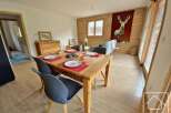 This charming property features a cozy dining area with a wooden table and stylish chairs, perfect for enjoying meals.