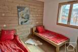 This cozy bedroom features two single beds with vibrant red bedding, perfect for a comfortable stay.