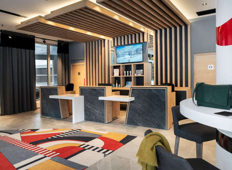 Step into the inviting lobby of this modern property, featuring a stylish reception area with sleek countertops and a striking geometric rug.