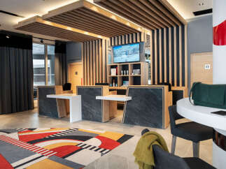 Step into the inviting lobby of this modern property, featuring a stylish reception area with sleek countertops and a striking geometric rug.