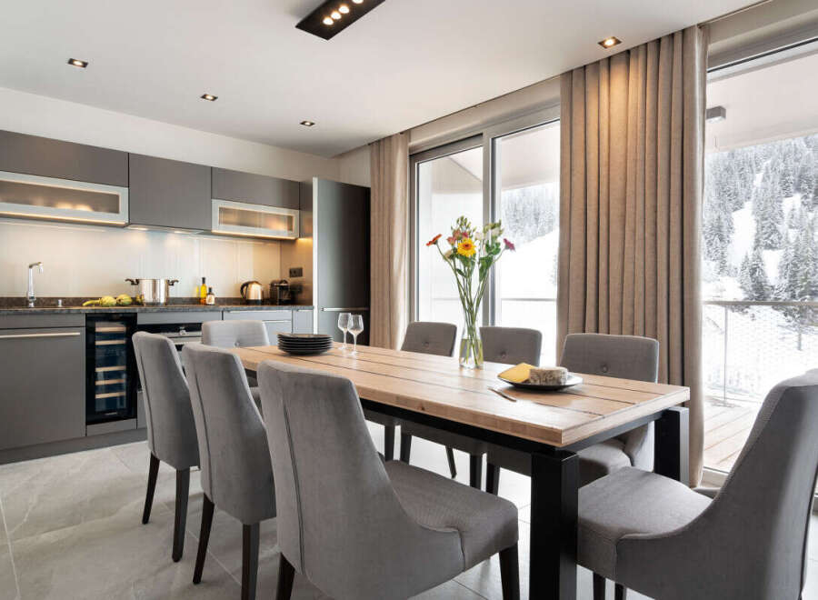 This modern kitchen and dining area offers a stylish space for both cooking and entertaining.