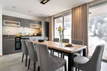 This modern kitchen and dining area offers a stylish space for both cooking and entertaining.