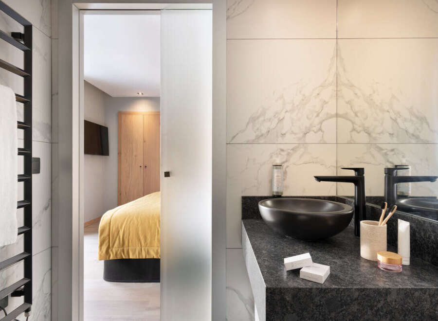 Step into luxury with this stunning bathroom, seamlessly connected to a stylish bedroom.