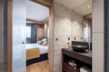 This stunning bathroom boasts a sleek, modern design with marble tiling and a dark granite countertop.