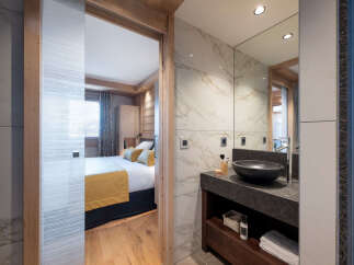 This stunning bathroom boasts a sleek, modern design with marble tiling and a dark granite countertop.