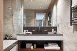 This luxurious bathroom boasts a spacious design with marble tiling, a large walk-in shower, and a modern double vanity with ample storage.