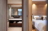 This stunning bedroom features a cozy wooden wall accent and plush bedding, creating a relaxing atmosphere.