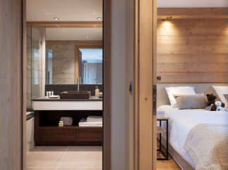 This stunning bedroom features a cozy wooden wall accent and plush bedding, creating a relaxing atmosphere.