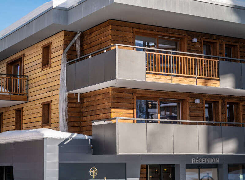The Manaka Hotel boasts a stunning modern design, featuring a striking combination of wood and gray accents.