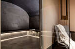 Indulge in ultimate relaxation in this luxurious private spa, featuring a sleek, modern steam room with a calming grey stone design and ambient lighting.