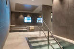 This luxurious spa features a stunning, modern design with sleek gray stone tiles and stainless steel accents.