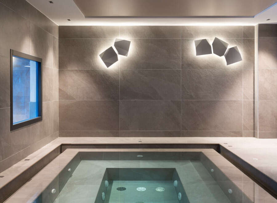 Indulge in tranquility at this luxurious spa, featuring a pristine indoor hot tub nestled within a sophisticated, tiled setting.
