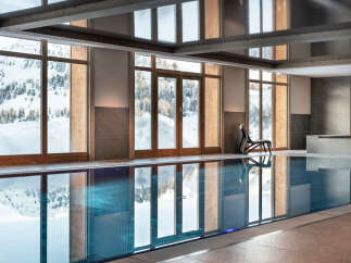 Indulge in the serene indoor pool, boasting floor-to-ceiling windows showcasing breathtaking snowy mountain views.
