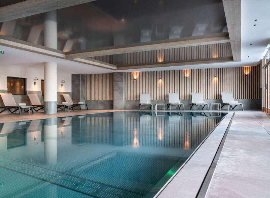 Indulge in the serene atmosphere of our indoor pool, featuring sleek design and calming lighting.
