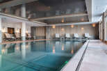 Indulge in the serene atmosphere of our indoor pool, featuring sleek design and calming lighting.