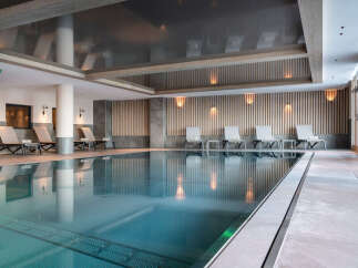 Indulge in the serene atmosphere of our indoor pool, featuring sleek design and calming lighting.
