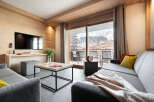 Experience luxury living in this stunning property, featuring a modern living room with a large TV and a cozy sofa.
