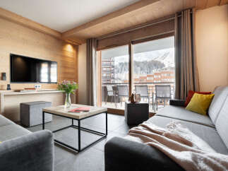 Experience luxury living in this stunning property, featuring a modern living room with a large TV and a cozy sofa.