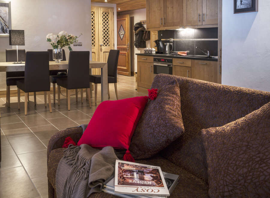This stunning apartment boasts an open-plan living area with a comfortable brown couch, perfect for relaxing after a day on the slopes.