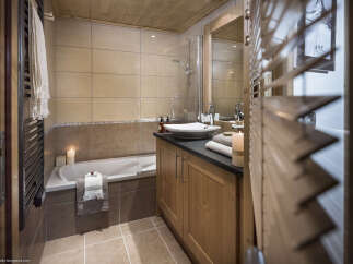 This luxurious bathroom boasts a spacious bathtub, a sleek modern sink, and plenty of storage space.