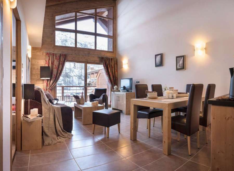 This stunning chalet boasts a spacious open-plan living area with floor-to-ceiling windows offering breathtaking mountain views.