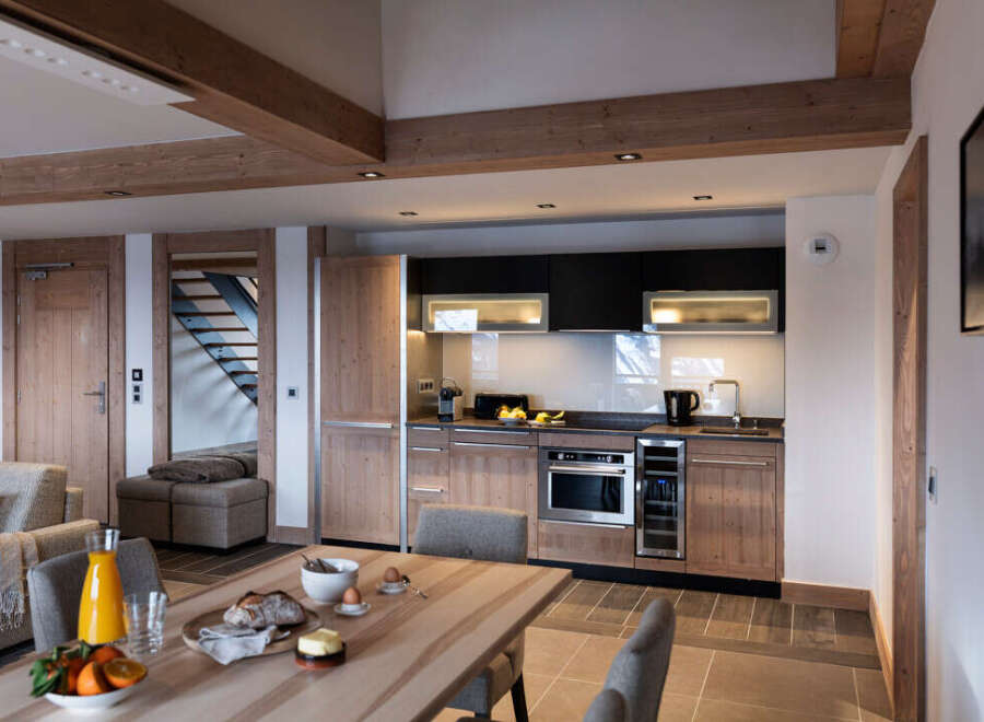 This stunning apartment boasts a spacious open-plan living area with a modern kitchen featuring sleek cabinetry and high-end appliances.