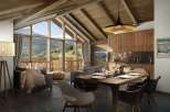 This stunning chalet boasts a spacious open-plan living area with floor-to-ceiling windows offering breathtaking mountain views.
