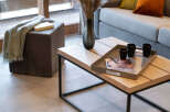Modern living room with a light grey sofa, wooden coffee table, and stylish decor.