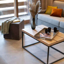 Modern living room with a light grey sofa, wooden coffee table, and stylish decor.